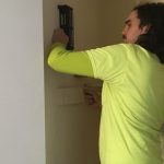 young man installing cabling in wall